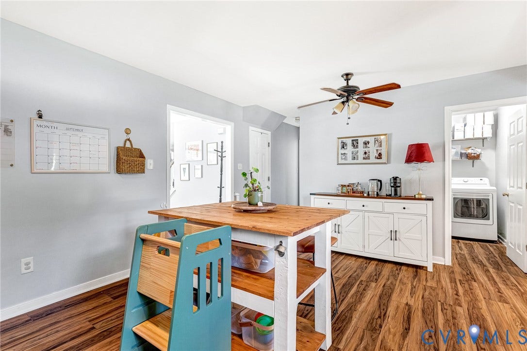 Wood-finish flooring throughout, white baseboards, and a ceiling fan with light fixture
