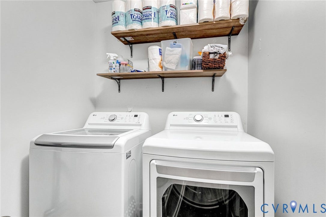 White walls with two wood-finish floating shelves featuring black brackets