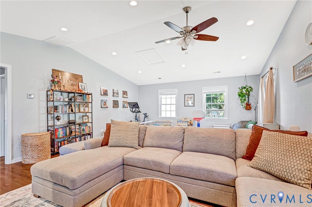 Sloped ceiling with recessed lighting and a ceiling fan