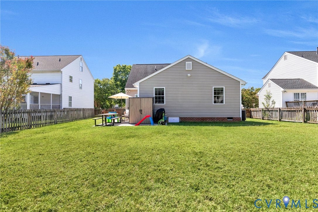 Expansive rear lawn, privacy fencing, and a concrete patio
