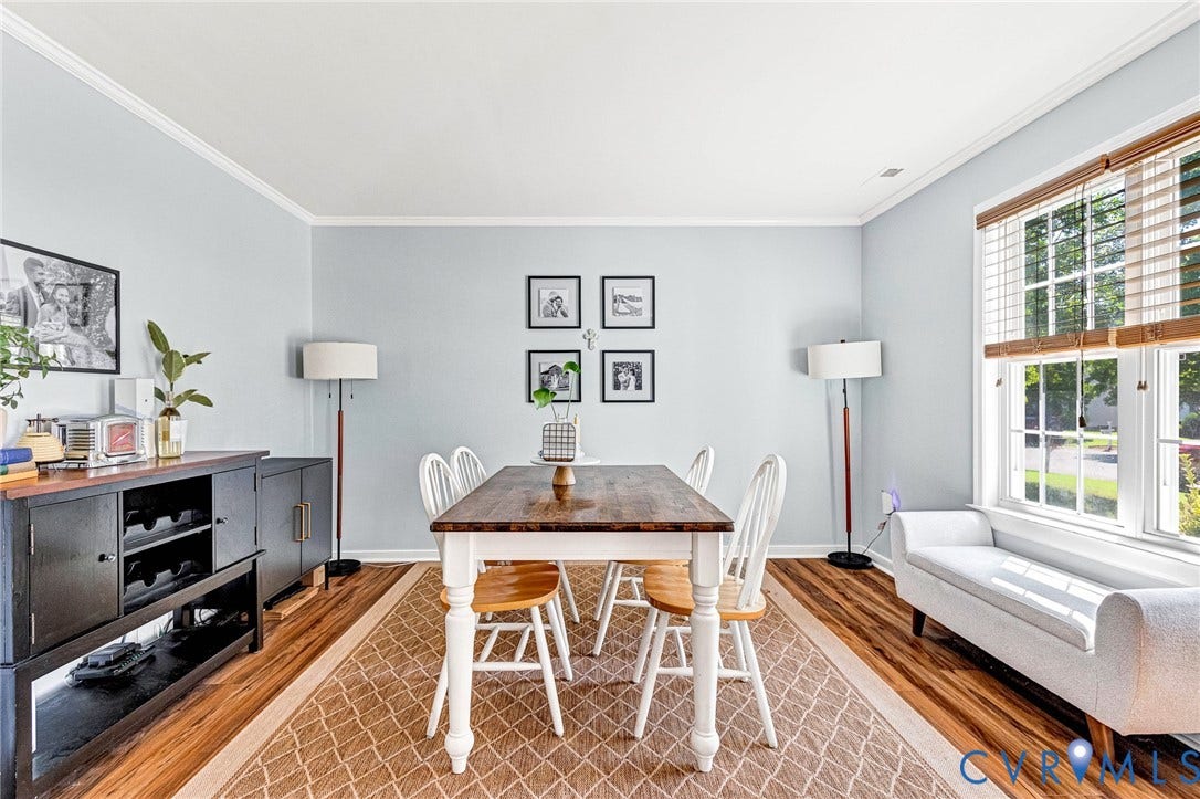 Wood-finish flooring, light blue wall color, white crown molding, and white window trim