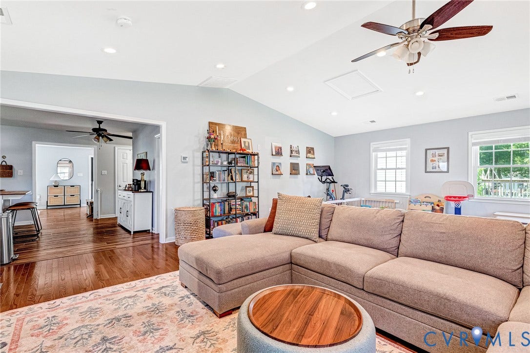 Vaulted ceiling with recessed lighting, wood-finish flooring, multiple windows, and a ceiling fan