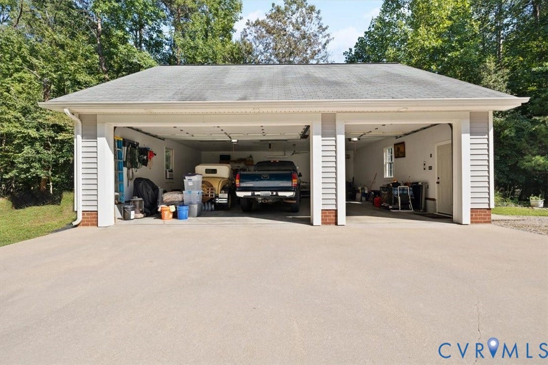 4398 Lynnecross Court, Powhatan, VA 23139 Two-car garage with white siding, brick accents, and a wide concrete driveway
