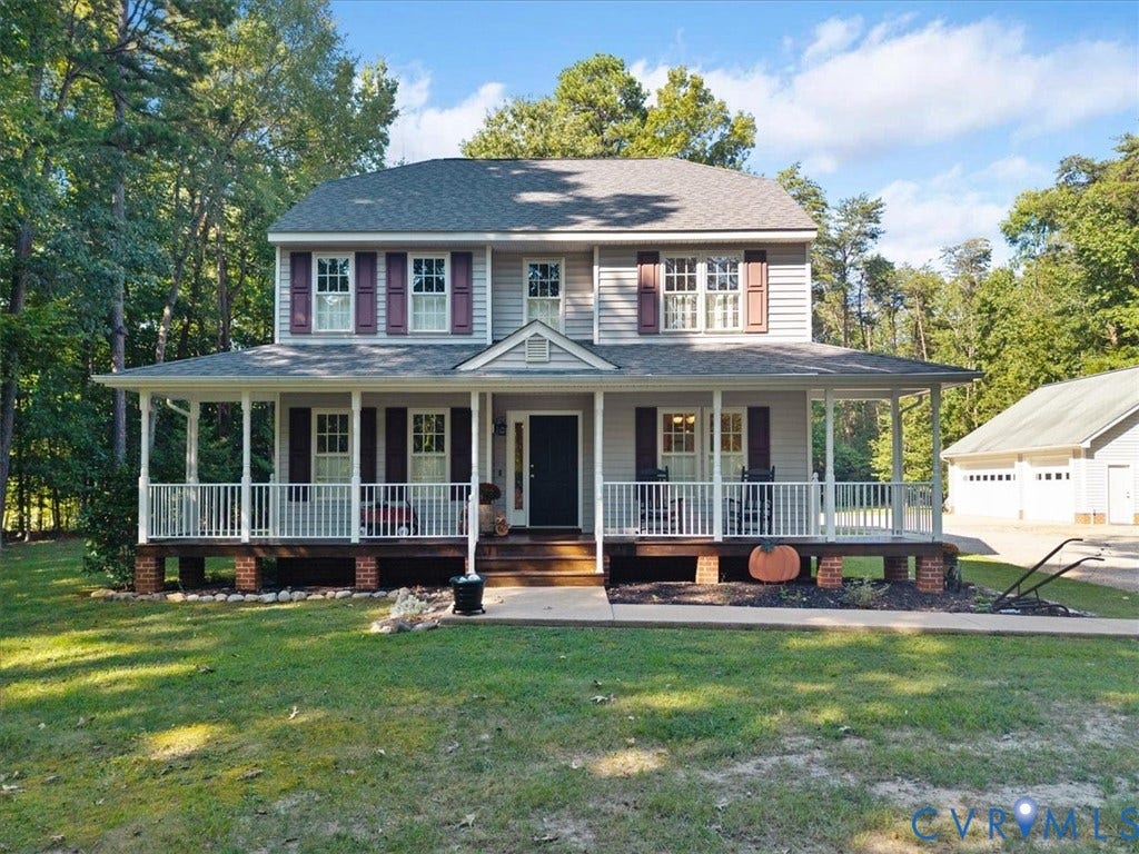 4398 Lynnecross Court, Powhatan, VA 23139 Two-story residence with gray siding, a full-width covered front porch, and a detached three-car garage