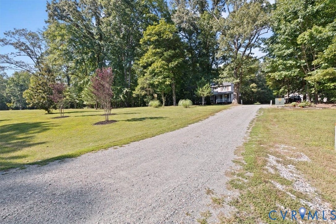 4398 Lynnecross Court, Powhatan, VA 23139 Gravel driveway framed by mature trees and a manicured lawn