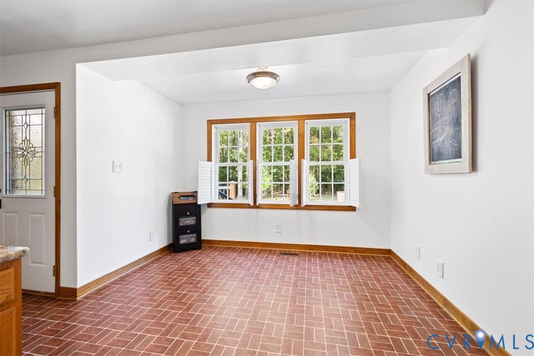 4398 Lynnecross Court, Powhatan, VA 23139 White walls complementing wood-finish trim, a decorative entry door with leaded glass, and three large windows with shutters