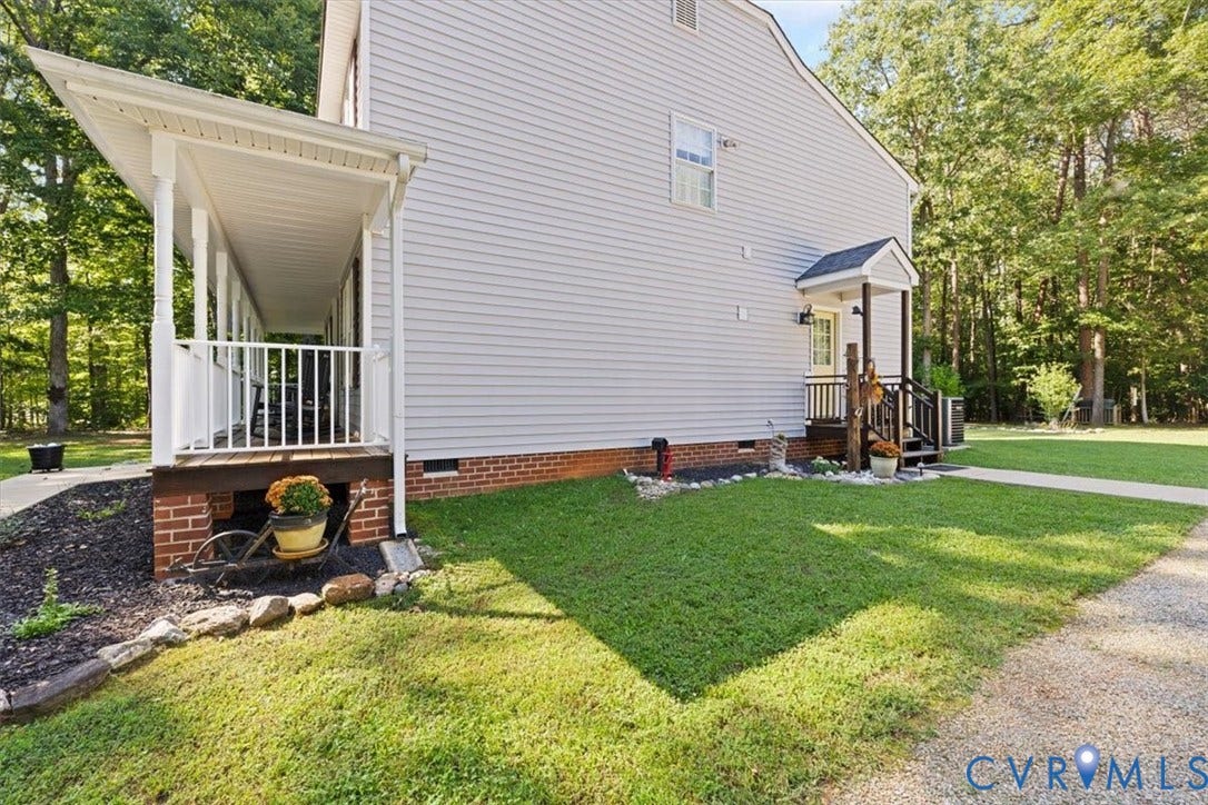 4398 Lynnecross Court, Powhatan, VA 23139 Siding exterior featuring a covered porch, brick foundation, and a gravel driveway