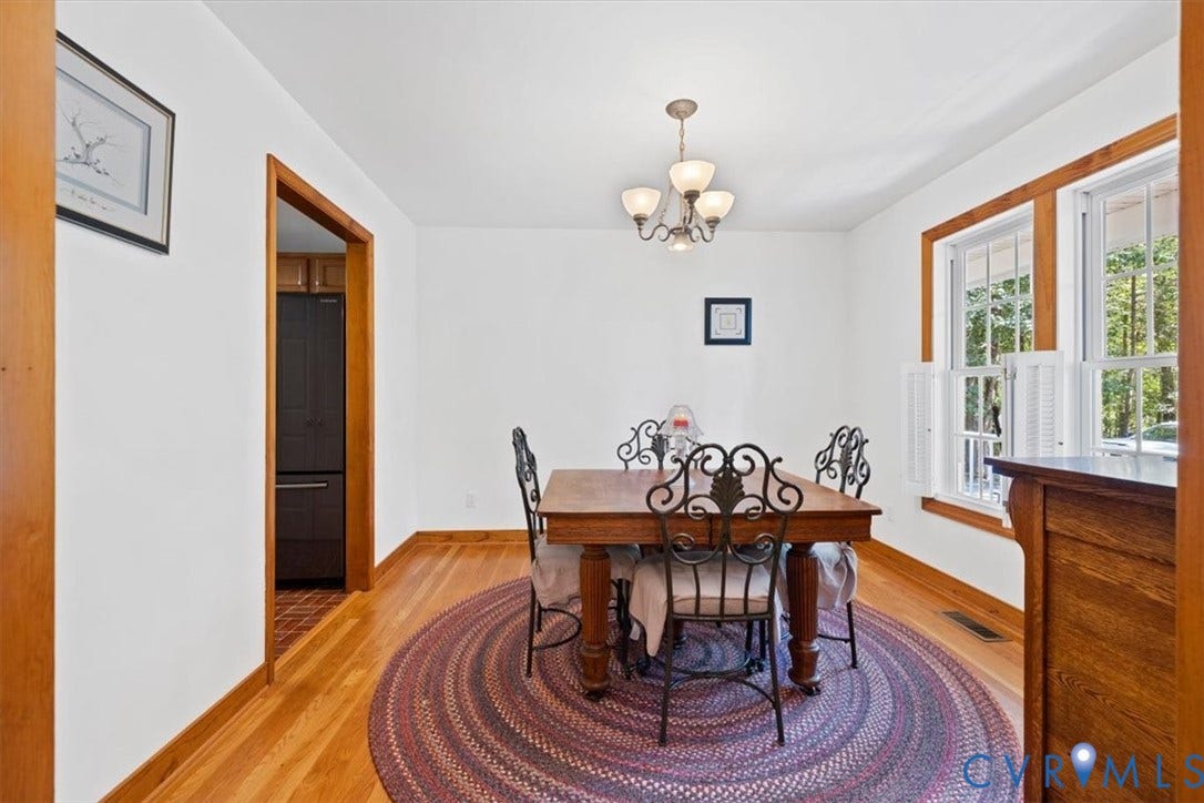 4398 Lynnecross Court, Powhatan, VA 23139 Hardwood flooring throughout, bright white walls, natural wood trim, window shutters, and a classic chandelier