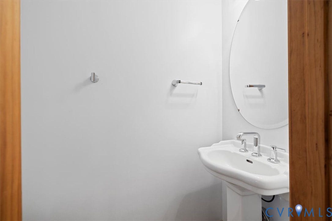 4398 Lynnecross Court, Powhatan, VA 23139 Pedestal sink with chrome fixtures, oval mirror, and polished chrome towel bar