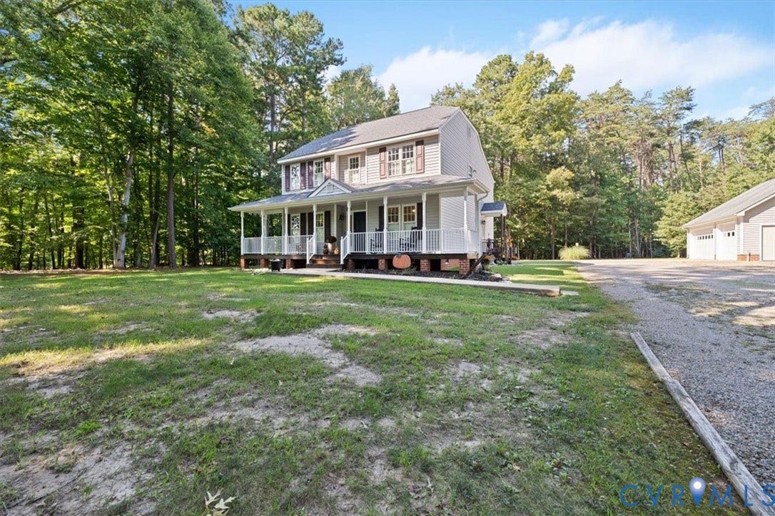 4398 Lynnecross Court, Powhatan, VA 23139 Two-story residence featuring a covered front porch, light-colored siding, and a multi-car detached garage