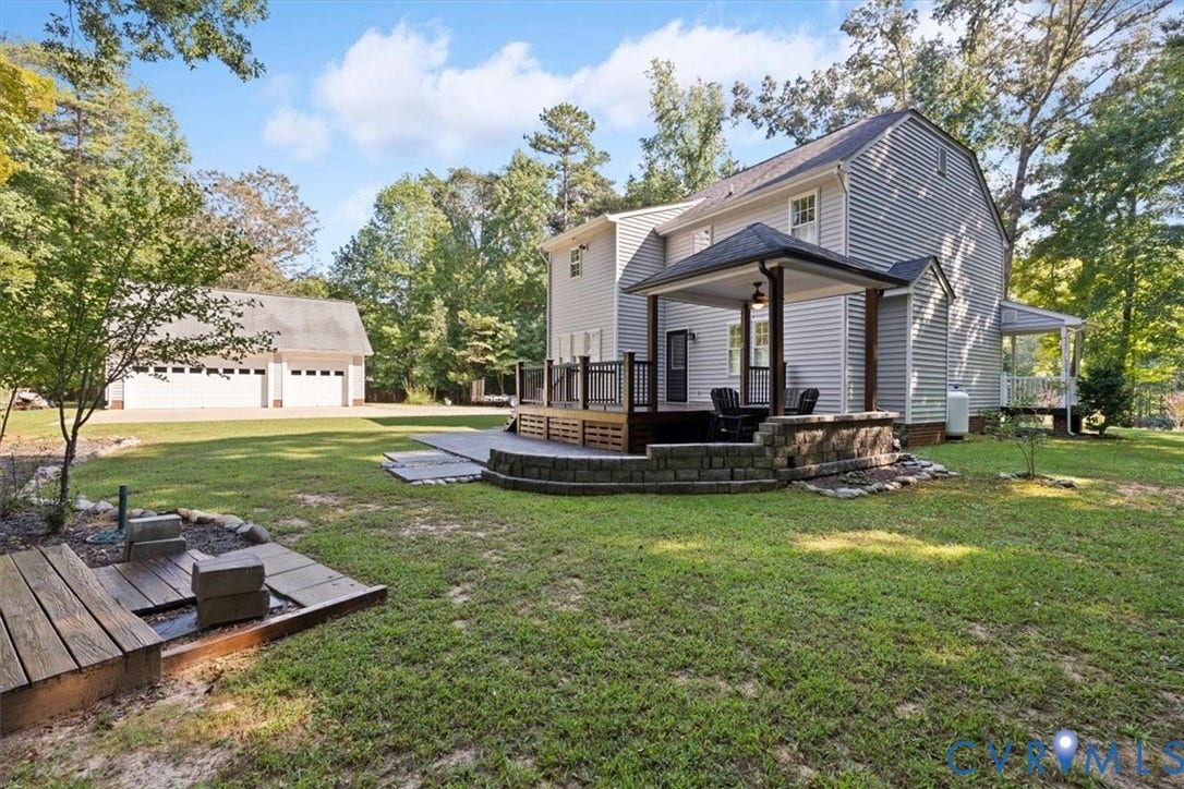 4398 Lynnecross Court, Powhatan, VA 23139 Siding exterior with multiple windows, leading to an elevated deck and a covered patio area
