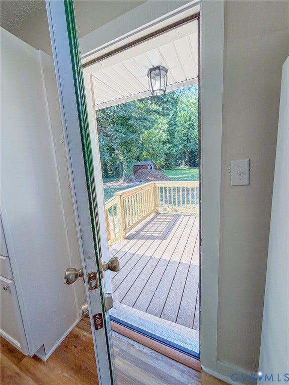 Exterior deck with wood-finish flooring, wood railings, and a covered porch