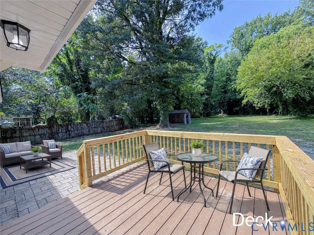 VIRTUALLY STAGED; Expansive rear yard featuring a wood-finish deck, paver patio, and mature tree-lined perimeter