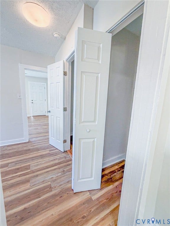 Wood-finish flooring throughout, white paneled bi-fold closet doors, and recessed ceiling lighting
