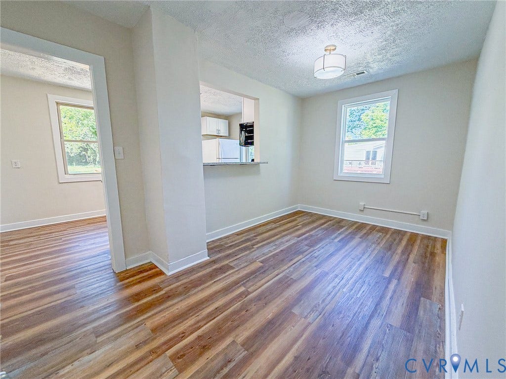Wood-finish flooring throughout, white trim, and a contemporary ceiling fixture