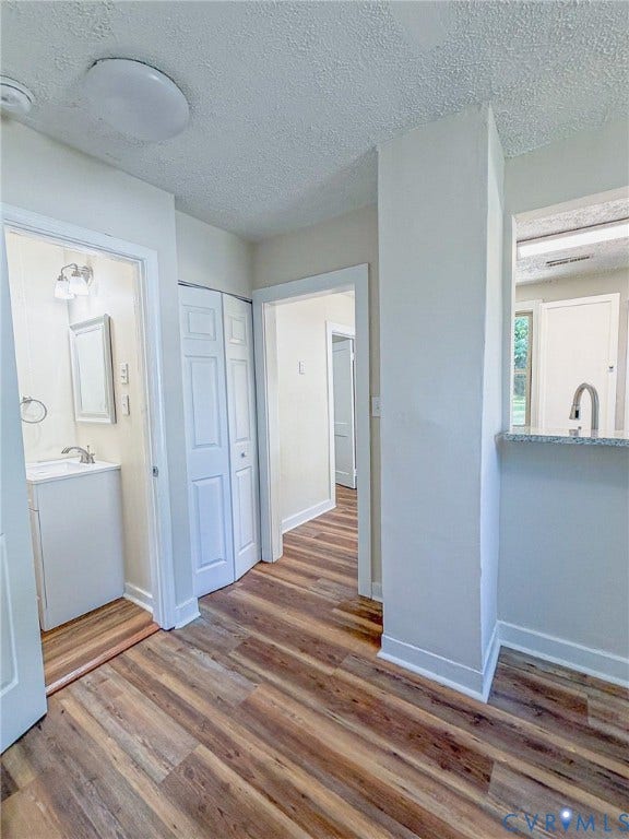 Wood-finish flooring throughout, bright white walls, and a pass-through opening