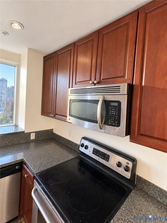 301 Virginia Street, #U703, Richmond, VA 23219 Kitchen featuring wood-finish cabinetry, stainless steel microwave, black electric range, and dark speckled countertops