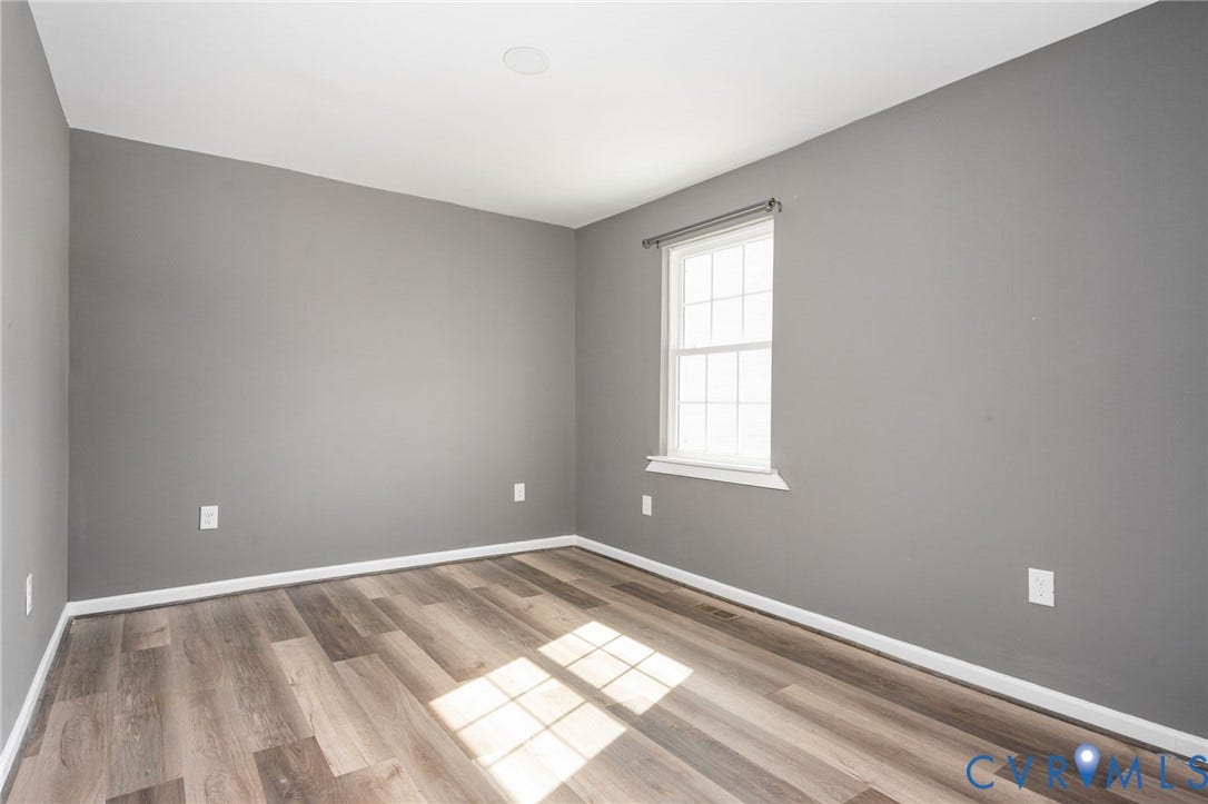 Wood-finish flooring, recessed ceiling lighting, and a window with white trim
