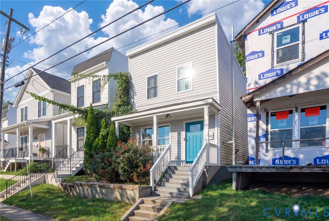 Two-story exterior with horizontal siding, covered front porch, and bright blue front door