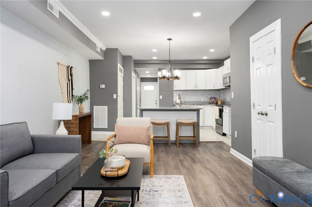 Open-concept living area with wood-finish flooring, recessed lighting, and crown molding