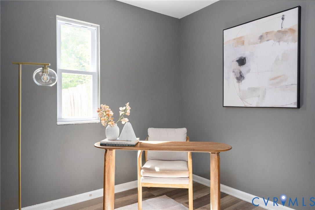 Vertical window providing natural light, gray wall finishes, wood-finish flooring, and white trim