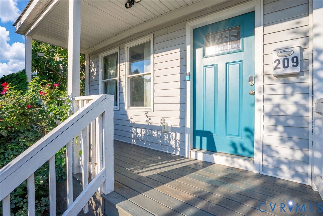 Covered front porch with wood-finish decking and white painted railing