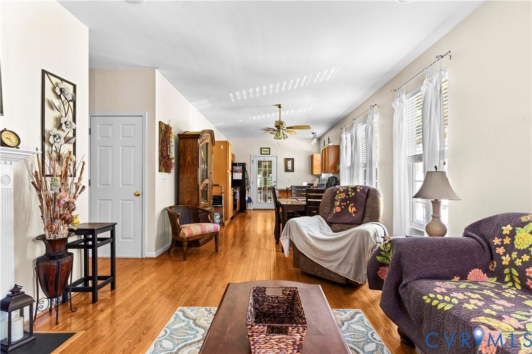 307 Poplar Dr, Louisa, VA 23093 Hardwood flooring throughout, multiple windows with white blinds, neutral wall paint, ceiling fan with integrated lighting, and a white six-panel interior door