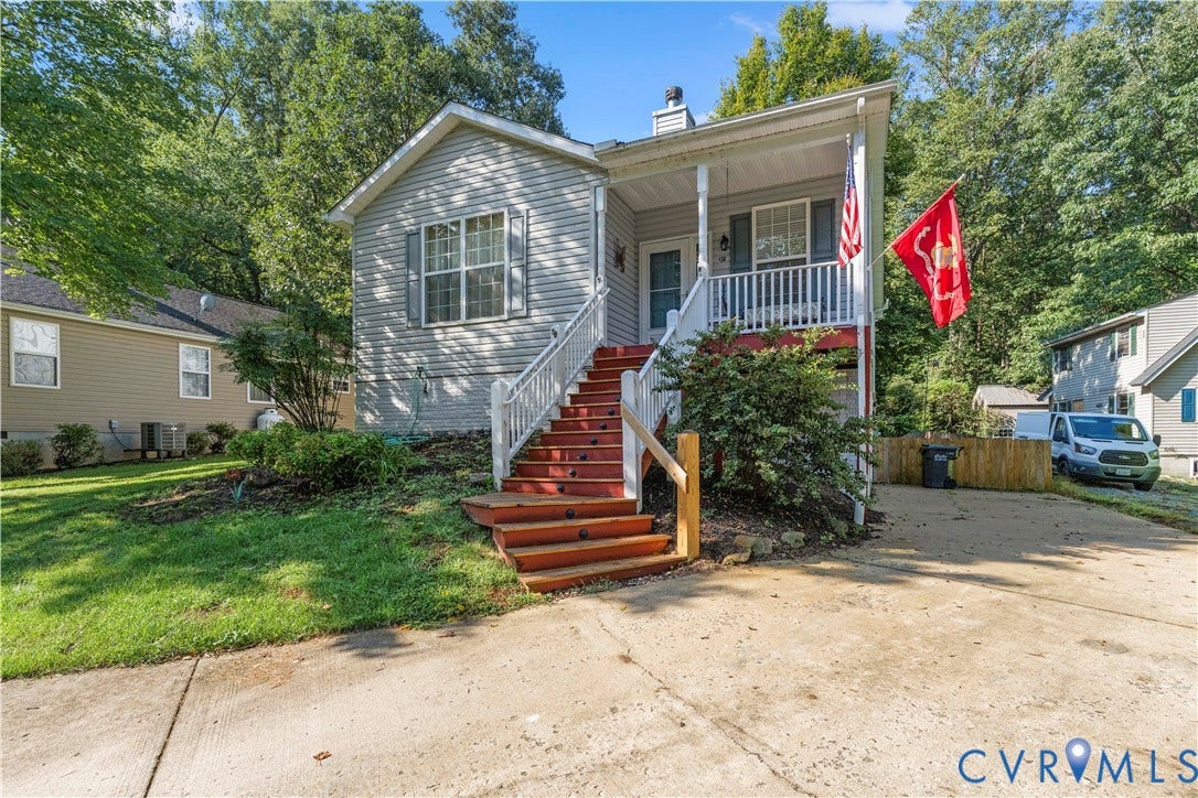 307 Poplar Dr, Louisa, VA 23093 Siding exterior with a covered front porch, red-stained wooden stairs, white railings, and a concrete driveway