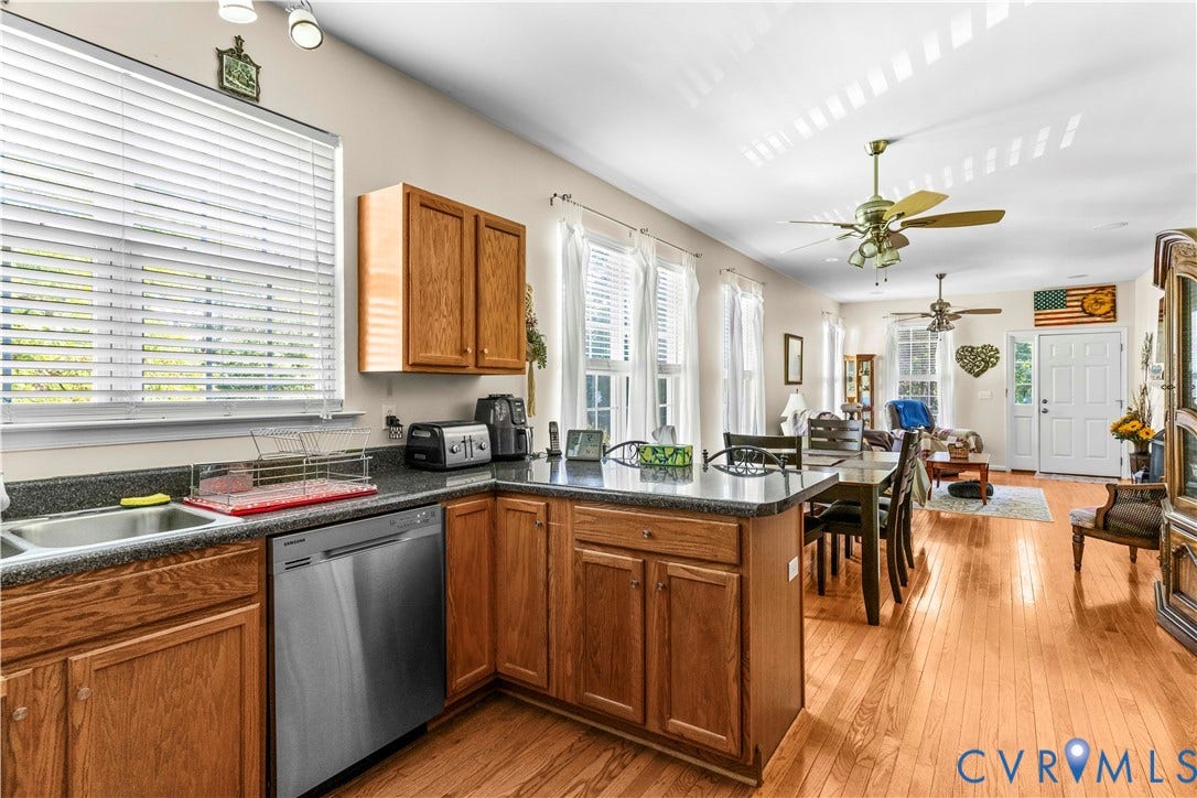 307 Poplar Dr, Louisa, VA 23093 U-shaped kitchen with dark countertops, stainless steel dishwasher, wood-finish cabinetry, and a double basin sink