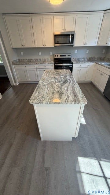 1424 Decatur Street, Rhodes Plan, Richmond, VA 23224 Kitchen featuring a central island with stone countertop, white cabinetry, stainless steel microwave, and wood-finish flooring