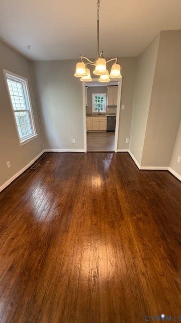 1424 Decatur Street, Rhodes Plan, Richmond, VA 23224 Wood-finish flooring with a satin finish, neutral wall paint, and a classic chandelier with frosted glass shades