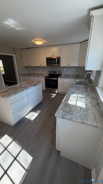 1424 Decatur Street, Rhodes Plan, Richmond, VA 23224 Kitchen featuring an island, white cabinetry, granite countertops, stainless steel microwave, and wood-finish flooring