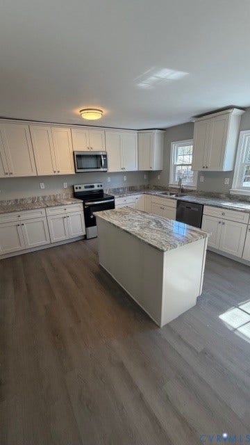 1424 Decatur Street, Rhodes Plan, Richmond, VA 23224 Kitchen featuring white cabinetry, a central island with a stone countertop, a stainless steel microwave, and wood-finish flooring