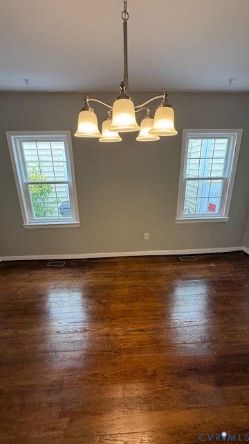 1424 Decatur Street, Rhodes Plan, Richmond, VA 23224 Wood-finish flooring with baseboard trim, two double-hung windows, and a five-light chandelier with frosted glass shades