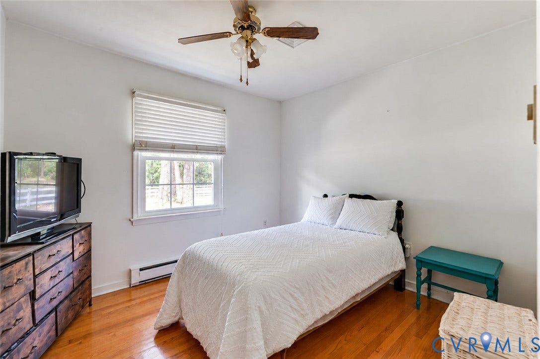 Hardwood-finish flooring, white walls, and a window with blinds