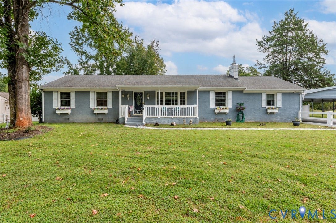 Ranch-style residence featuring a covered front porch, white window shutters, and a front yard