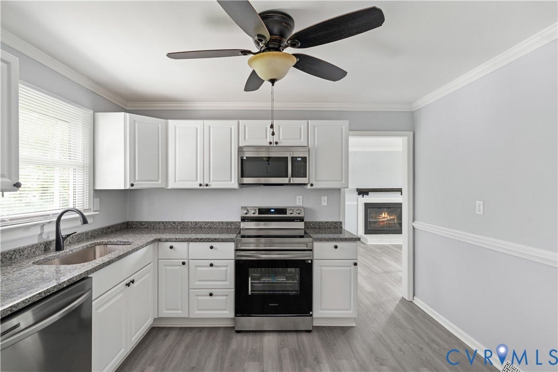 5221 Ecoff Avenue, Chester, VA 23831 Updated kitchen featuring white cabinetry, stainless steel appliances, dark countertops, and wood-finish flooring