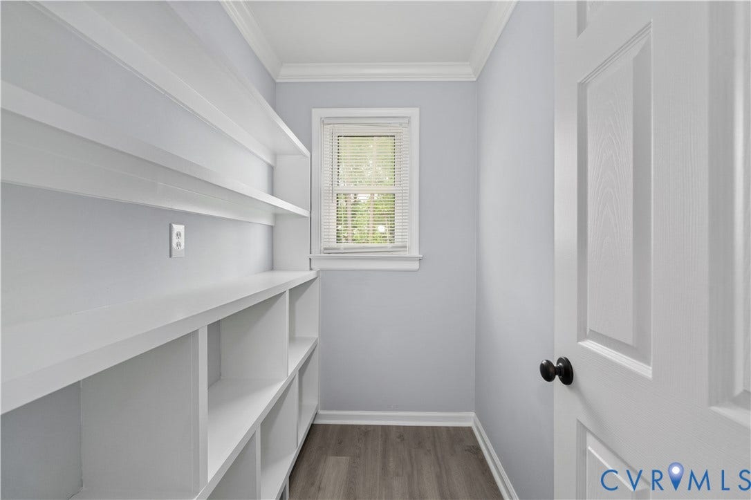 5221 Ecoff Avenue, Chester, VA 23831 Built-in shelving, wood-finish flooring, crown molding, white trim, and a paneled door with matte black hardware