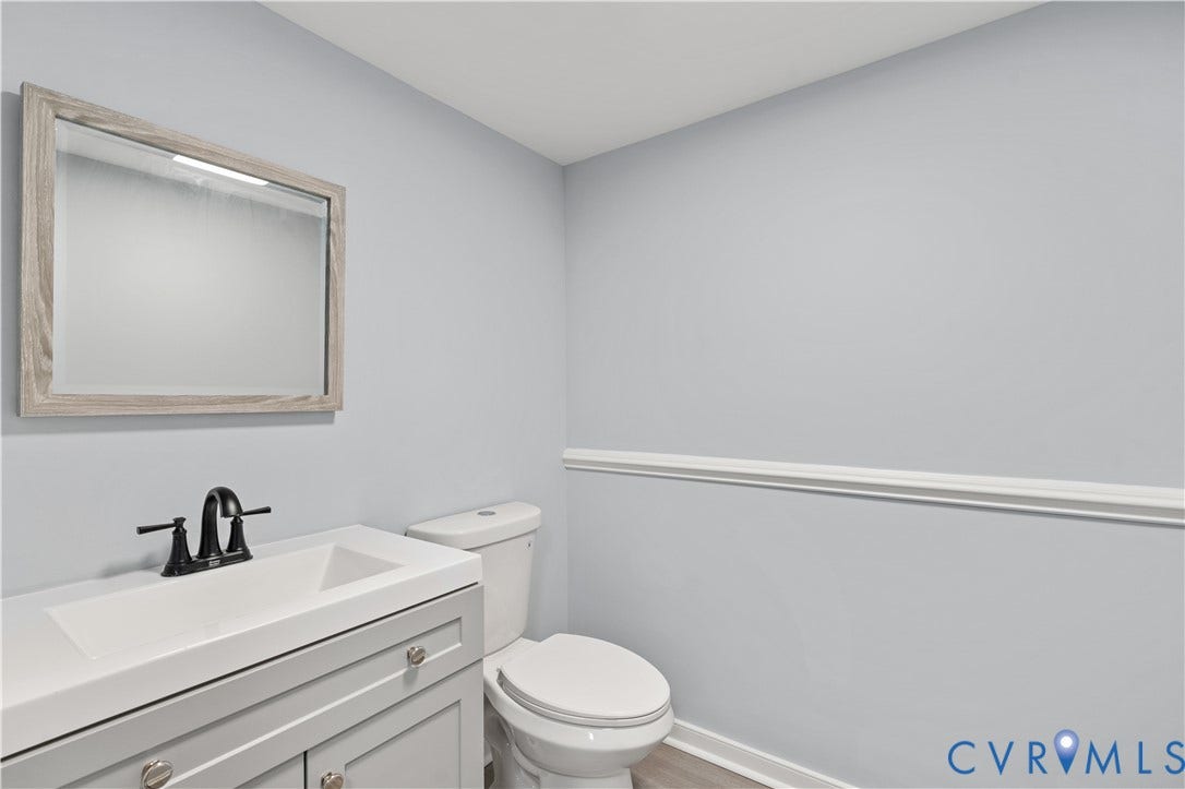 5221 Ecoff Avenue, Chester, VA 23831 Light blue wall color, crown molding, wood-finish flooring, vanity with integrated sink, and matte black faucet