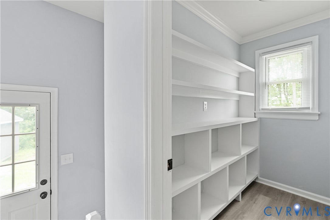 5221 Ecoff Avenue, Chester, VA 23831 Built-in shelving with multiple compartments, a large window with blinds, wood-finish flooring, and crown molding