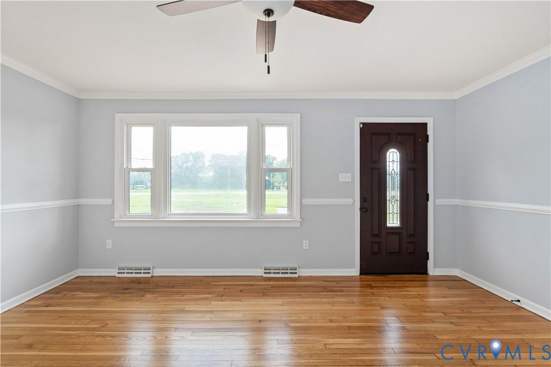 5221 Ecoff Avenue, Chester, VA 23831 Hardwood flooring, multi-panel window, decorative crown molding, chair rail molding, and a ceiling fan with light fixture