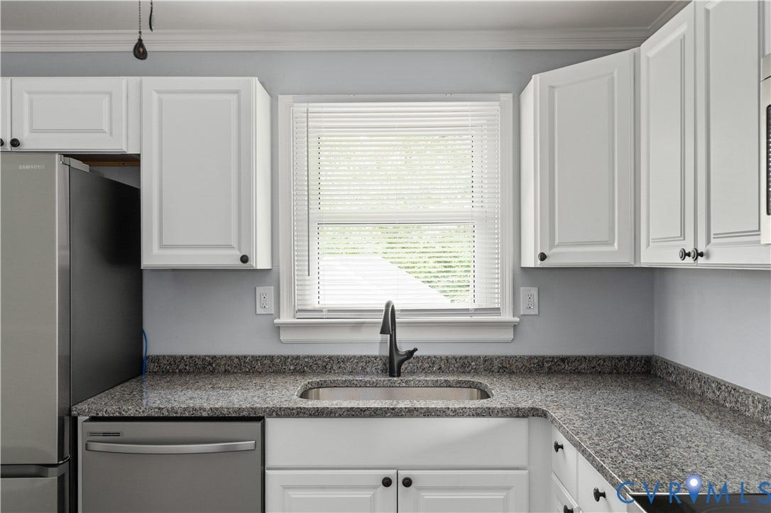 5221 Ecoff Avenue, Chester, VA 23831 White cabinetry with dark hardware, granite-style countertops, undermount stainless steel sink, and a black faucet