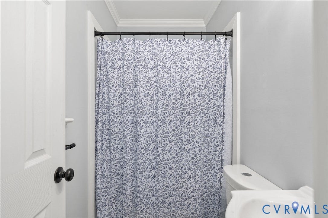5221 Ecoff Avenue, Chester, VA 23831 Bathroom featuring a white toilet, white wall-mounted sink, matte black hardware, and crown molding