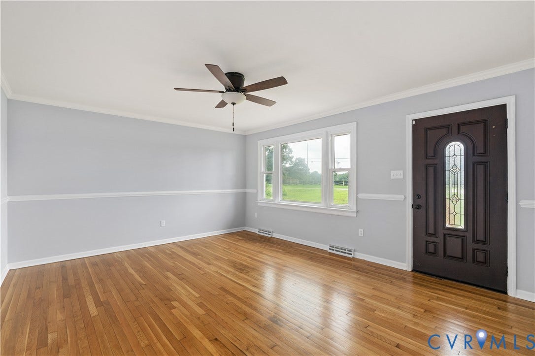 5221 Ecoff Avenue, Chester, VA 23831 Wood-finish flooring, ceiling fan, white window trim, decorative front door with leaded glass insert, and crown molding