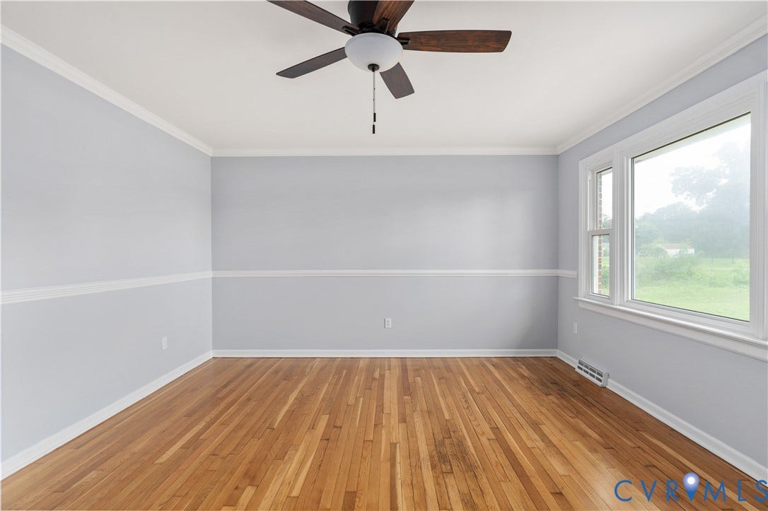 5221 Ecoff Avenue, Chester, VA 23831 Hardwood flooring and crown molding accent the space, complemented by a ceiling fan with integrated lighting and a large window