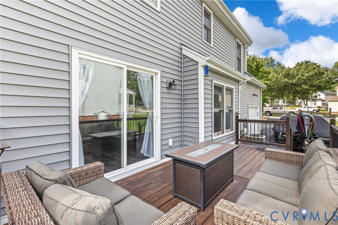7625 Southford Lane, Chesterfield, VA 23832 Expansive wood-finish deck with dark wood railings, featuring a sliding glass door and gray horizontal siding
