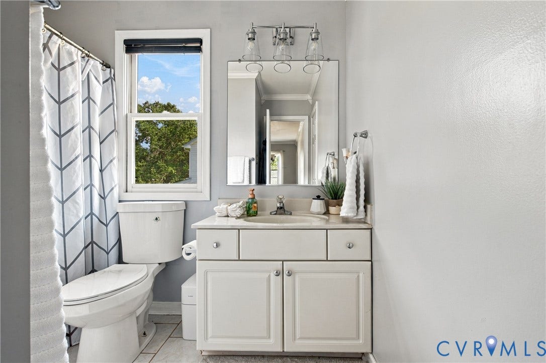 7625 Southford Lane, Chesterfield, VA 23832 Bathroom featuring a white vanity with integrated sink, chrome faucet, wall-mounted mirror, and overhead light fixture