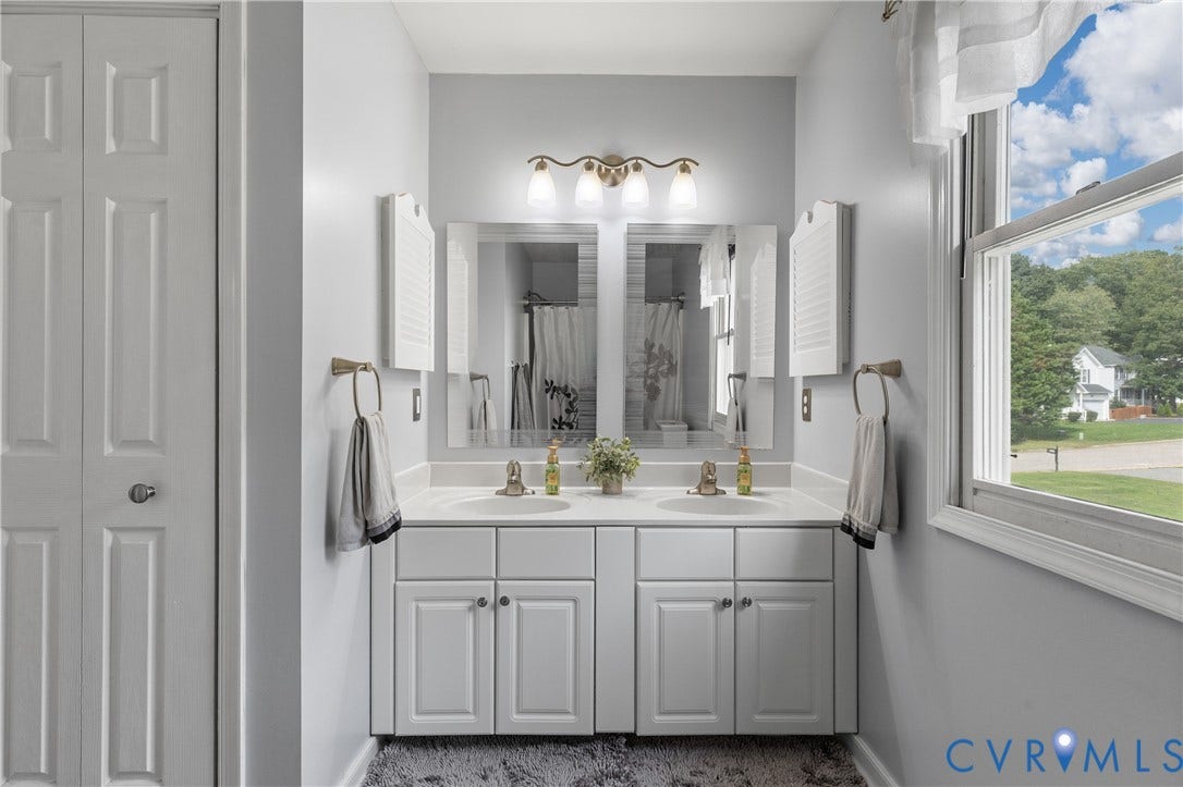7625 Southford Lane, Chesterfield, VA 23832 Dual vanity with white cabinetry and integrated sinks, under a three-light fixture
