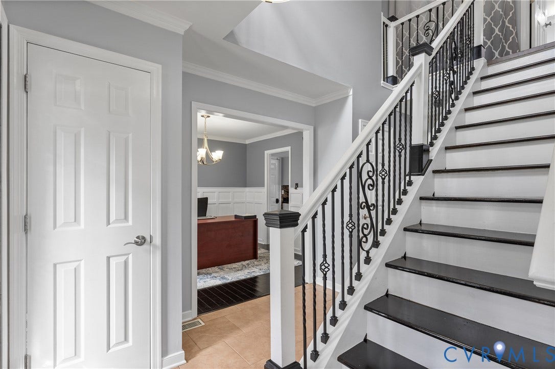 7625 Southford Lane, Chesterfield, VA 23832 Two-story foyer with tile flooring, staircase featuring wrought iron balusters and dark wood treads, crown molding, and wainscoting