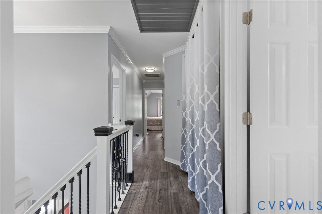 7625 Southford Lane, Chesterfield, VA 23832 Hallway with wood-finish flooring, white trim, and a black wrought-iron railing